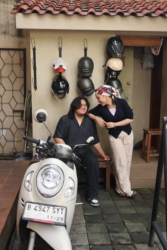Addin on a scooter with Umairah leaning beside him